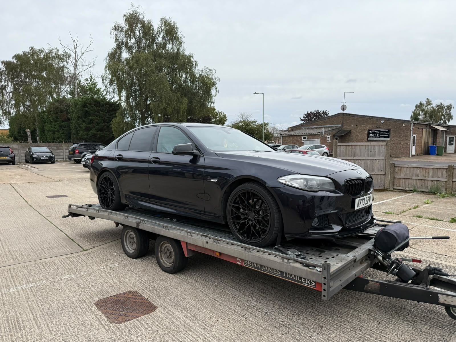 Black BMW 5 Series loaded and strapped on the SV Transport car transporter trailer