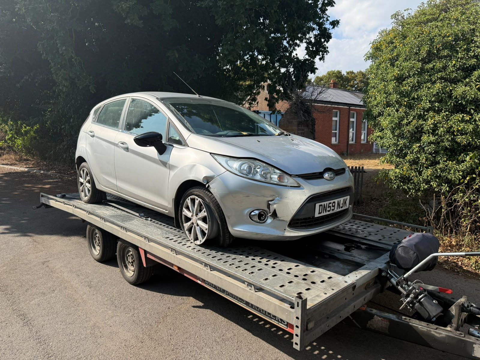 Silver Ford Fiesta with front-end accident damage loaded on the SV Transport trailer